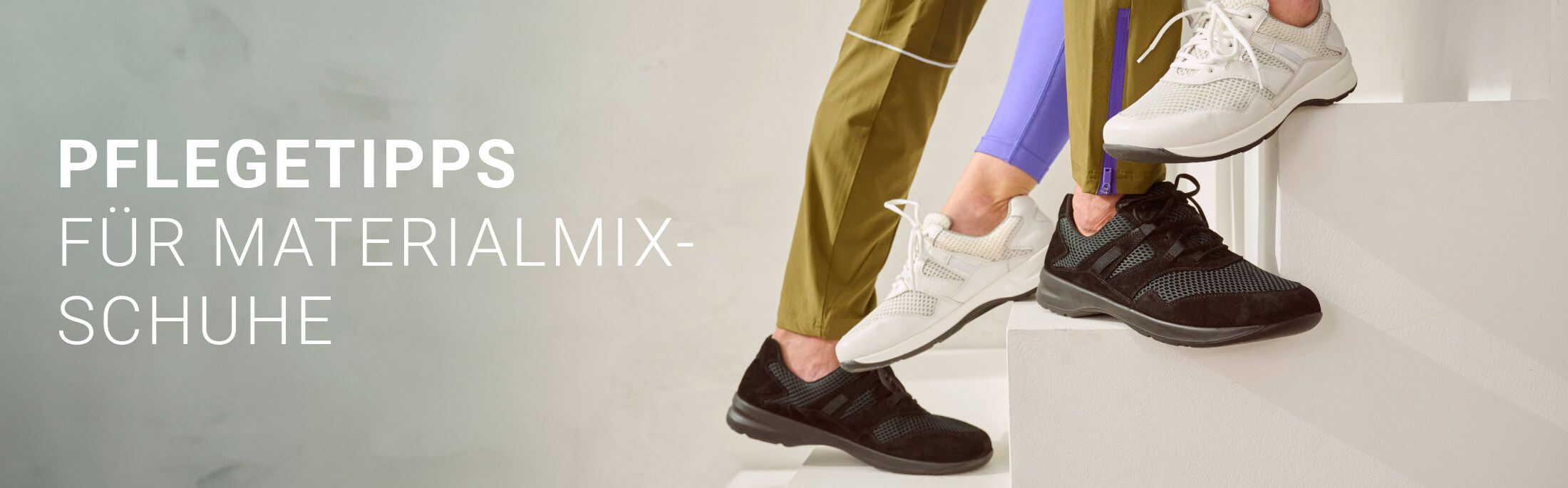 Zwei Personen tragen weiße und schwarze Materialmix-Schuhe, während sie auf einer Treppe stehen. Text: Pflegetipps für Materialmix-Schuhe.